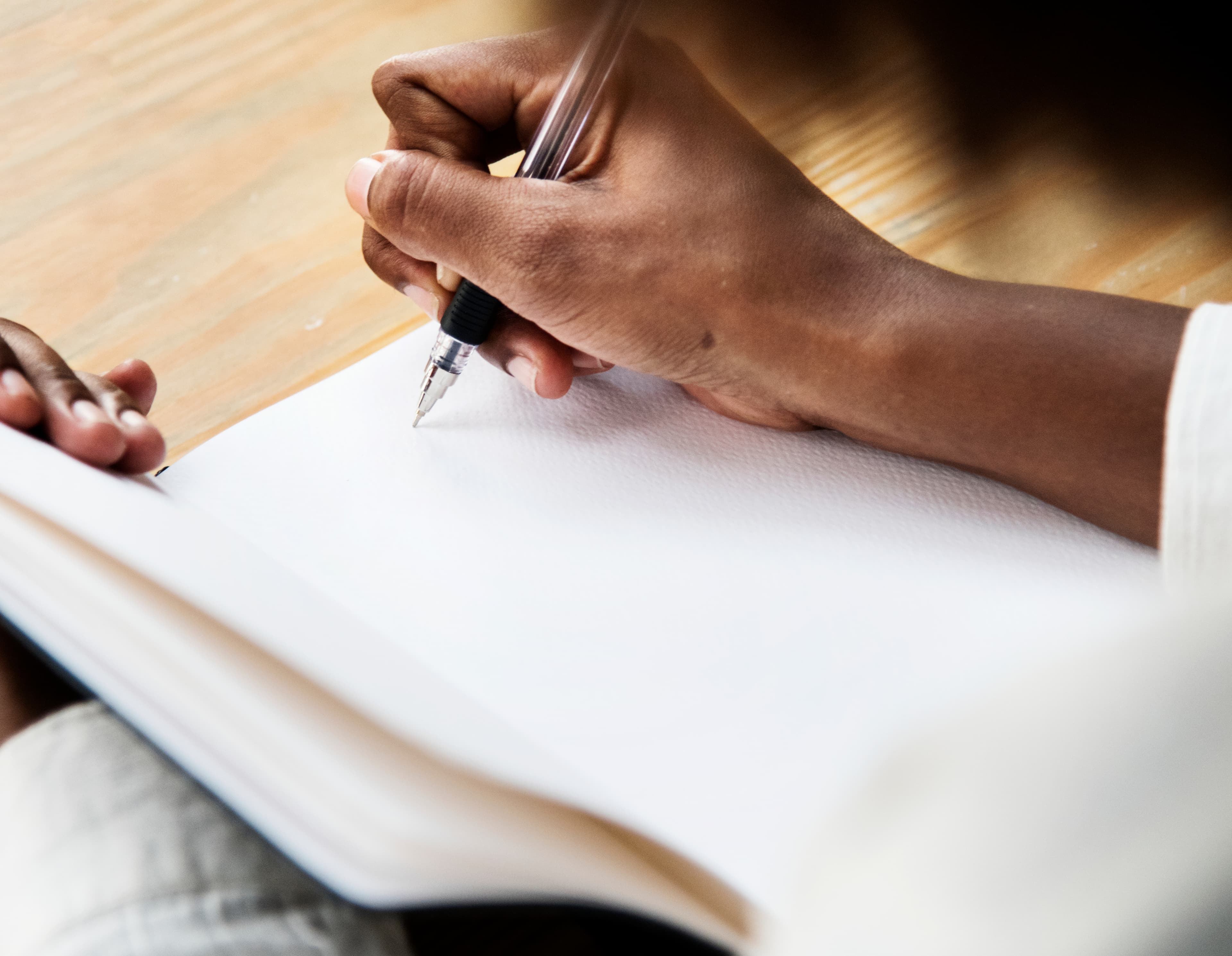 Pessoa escrevendo em um caderno — capacitação e treinamento